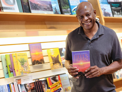 Anthony Florence holding his book Hell's Heaven in Reasonable Books, Lafayette.